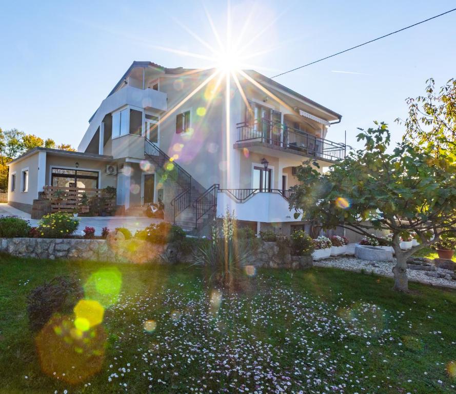 una casa bianca con il sole che splende sopra di Apartments Meri a Sveti Ivan