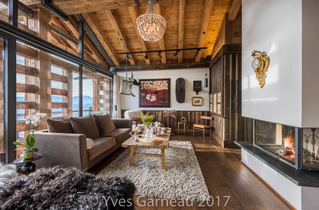 a living room with a couch and a fireplace at Artsy Luxurious Ski-In-Out-Chalet in Bagnes