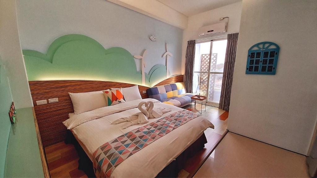 a bedroom with a large bed with a fish painted on the wall at Yurong B&amp;B in Magong