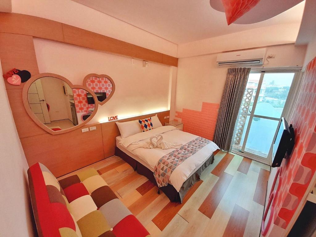 a bedroom with a bed and a mirror on the wall at Yurong B&amp;B in Magong