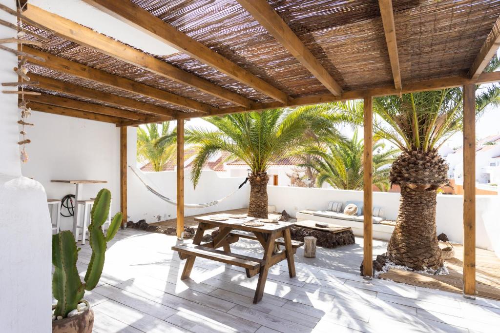 een patio met een tafel en 2 palmbomen bij Casa El Delfín in San Miguel de Abona
