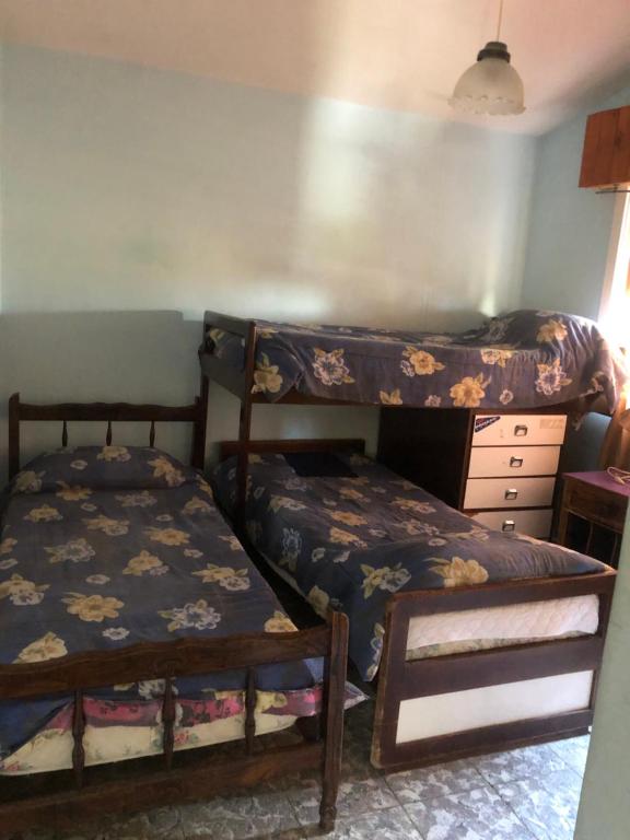 1 Schlafzimmer mit 2 Etagenbetten und einem Schreibtisch in der Unterkunft Alquiler de Casa en La Falda in La Falda