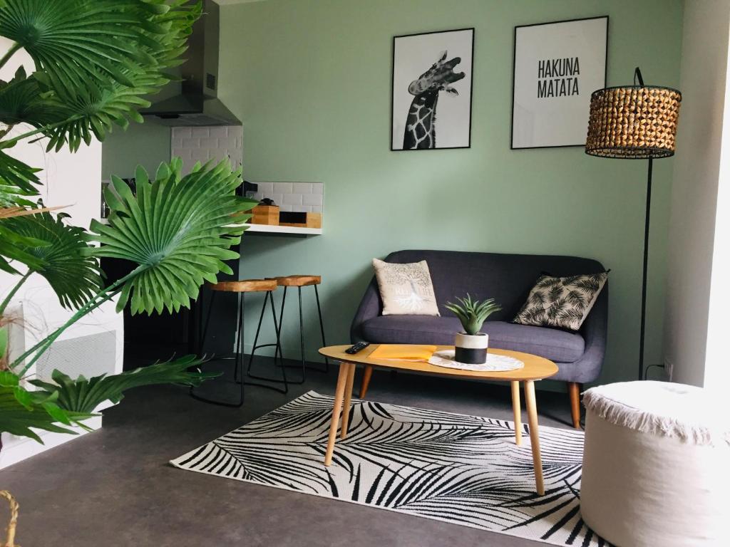 een woonkamer met een paarse bank en een tafel bij Grand Studio avec terrasse proche de l'hypercentre de Lorient in Lorient