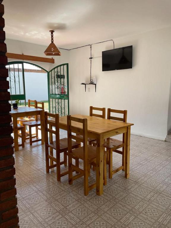 Un comedor con mesa y sillas y un televisor. en Hosteria EL PARRAL, en Mina Clavero