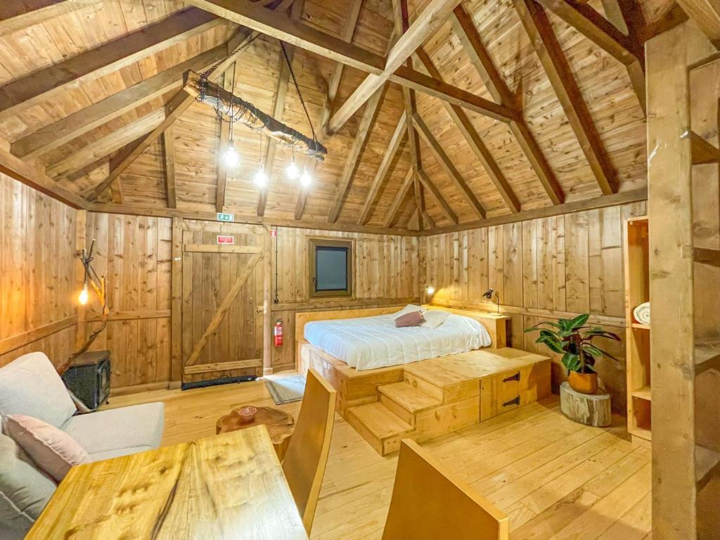 a bedroom in a wooden cabin with a bed and a table at Mountain Eco Shelters in Funchal