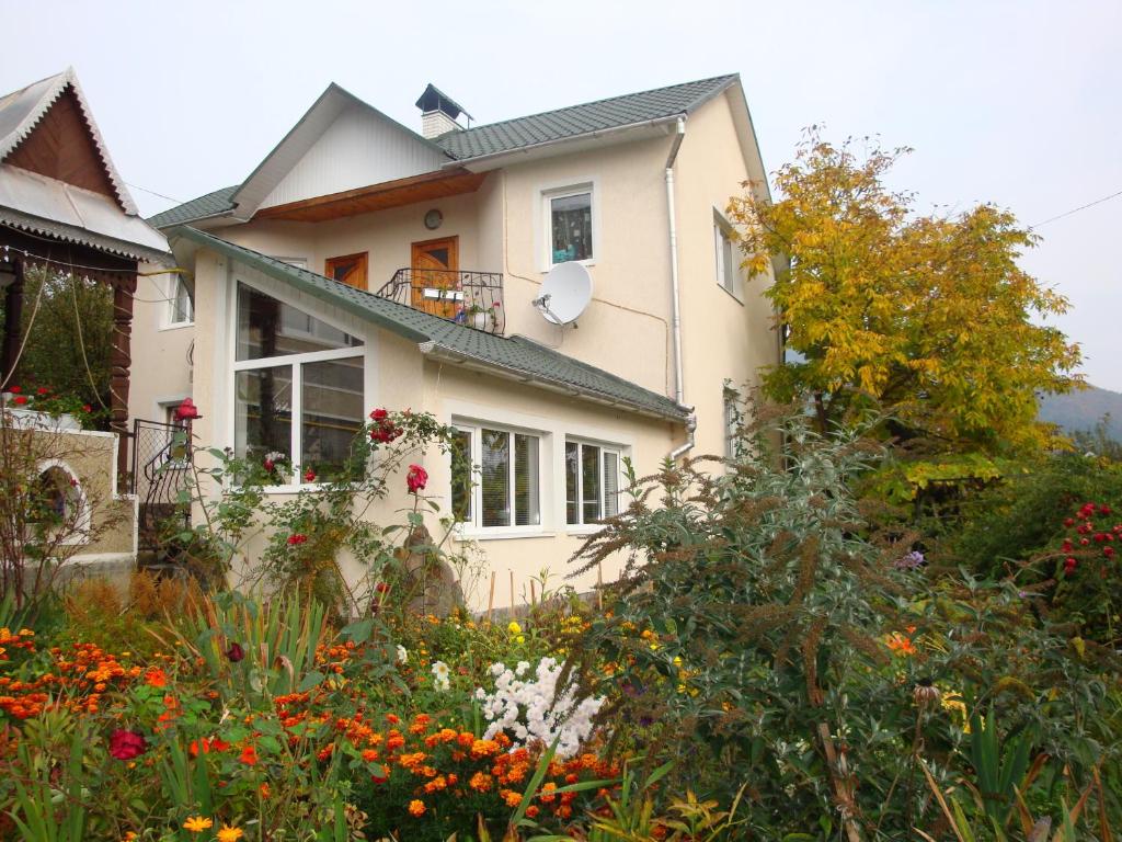 una casa con un jardín delante de ella en Vyshenka Guest House, en Yaremche