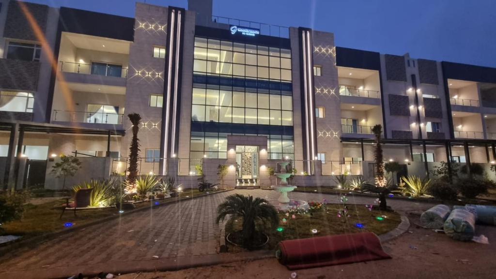 a large building with a courtyard in front of it at Grande Beach in Al Khīrān