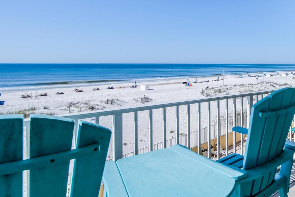 a blue beach chair sitting on a balcony overlooking the beach at Clearwater II in Gulf Shores