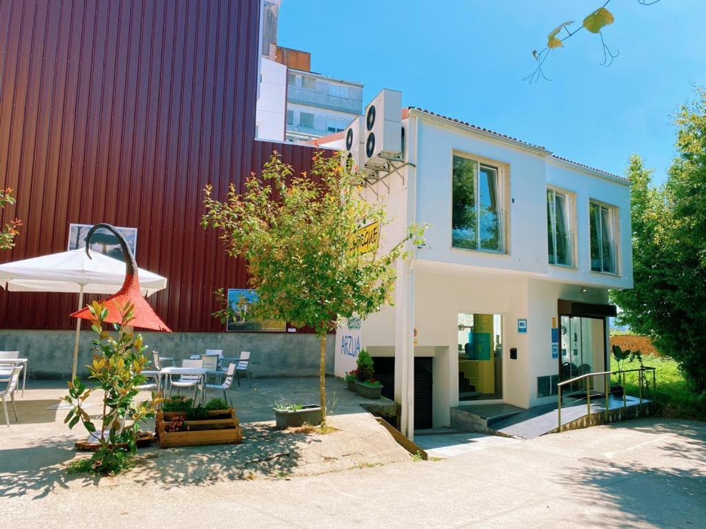 una casa con un árbol delante de un edificio en Cruce De Caminos Arzua, en Arzúa