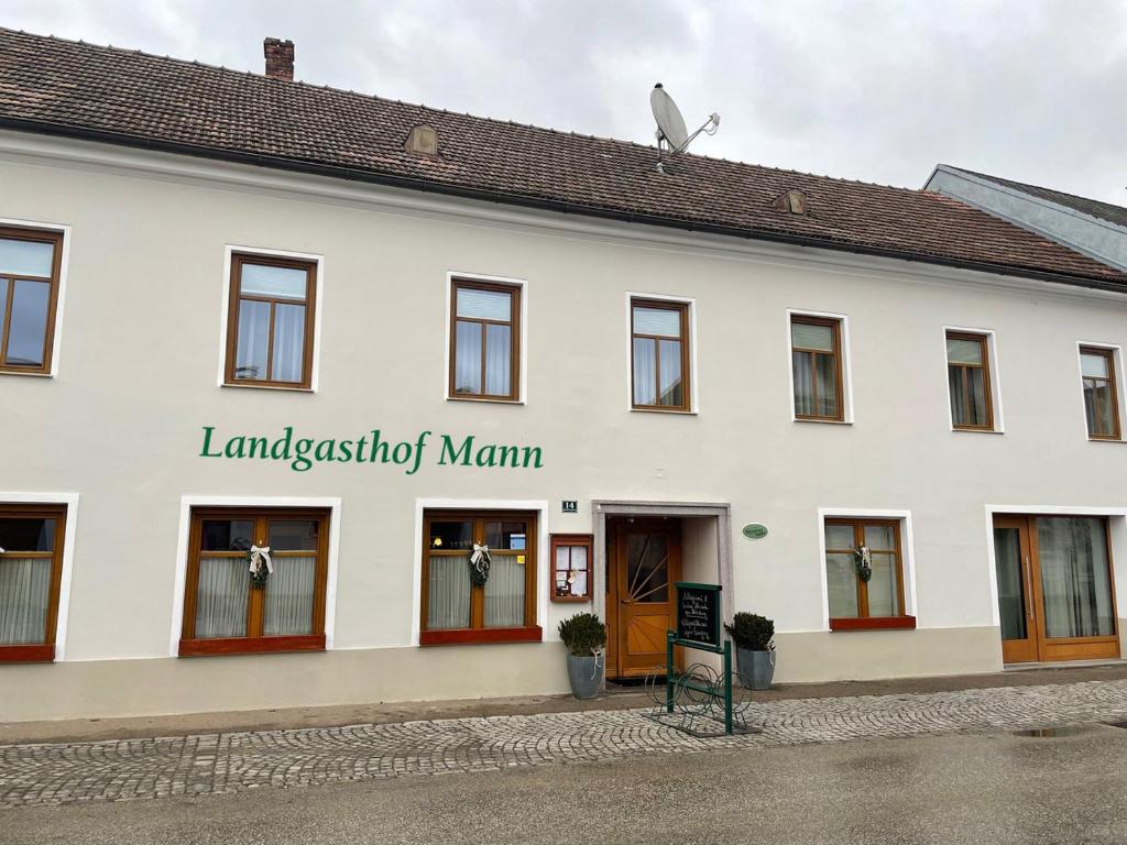 ein großes weißes Gebäude mit dem Namen des Manuskripts in der Unterkunft Königsbrunner Landgasthof in Königsbrunn