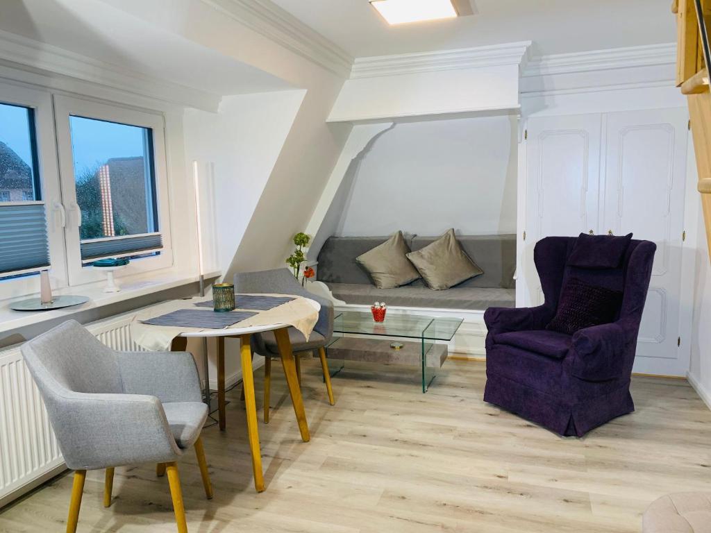 ein Wohnzimmer mit einem Tisch, Stühlen und einem Sofa in der Unterkunft Haus Westsee OG Friesenstil modern in Wenningstedt-Braderup