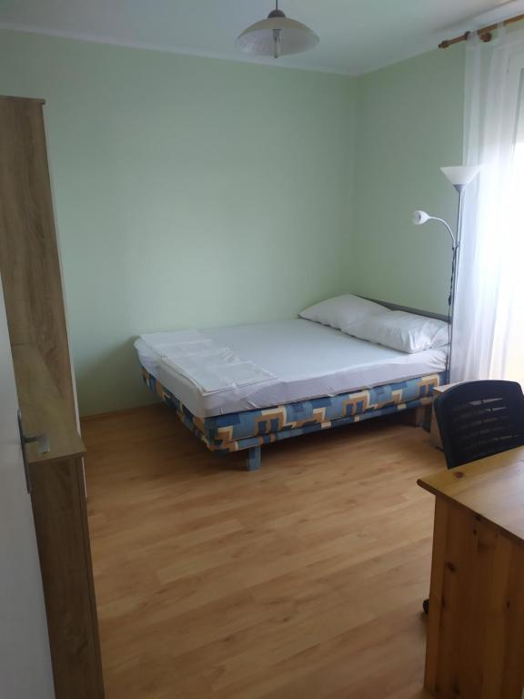 um quarto com uma cama no canto de um quarto em Hetedik Apartman em Pécs