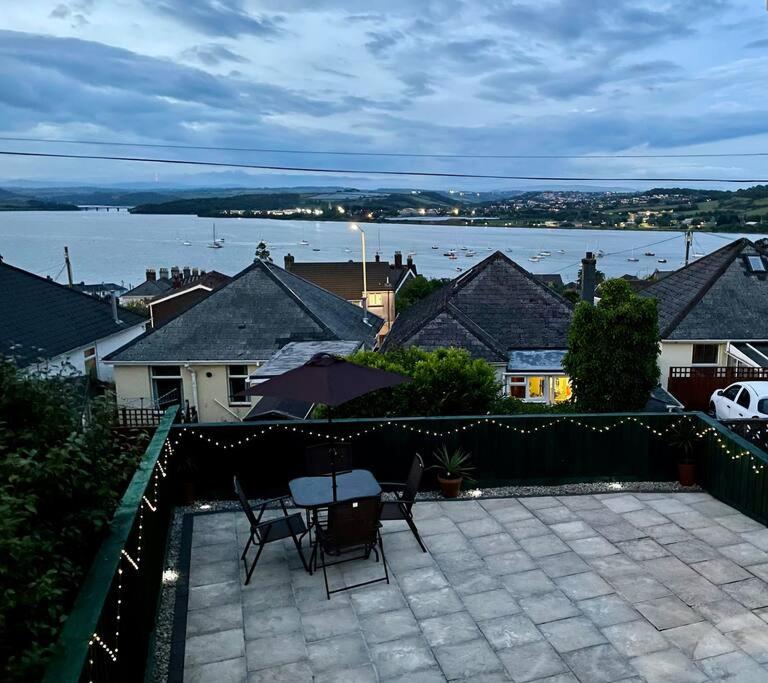 a patio with a table and chairs and a view of the water at Superb base for exploring Cornwall and Plymouth in Saltash