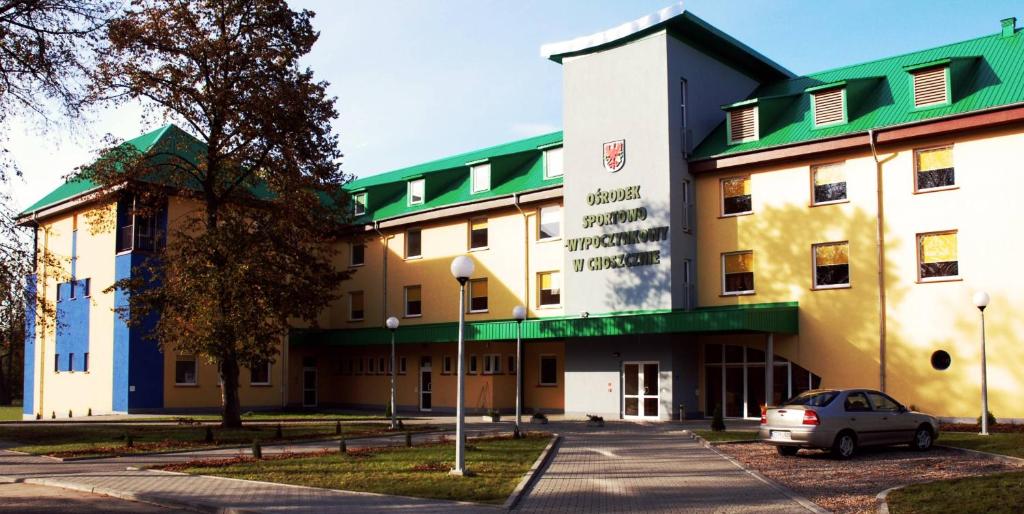 een gebouw waar een auto voor geparkeerd staat bij Ośrodek Sportowo-Wypoczynkowy in Choszczno