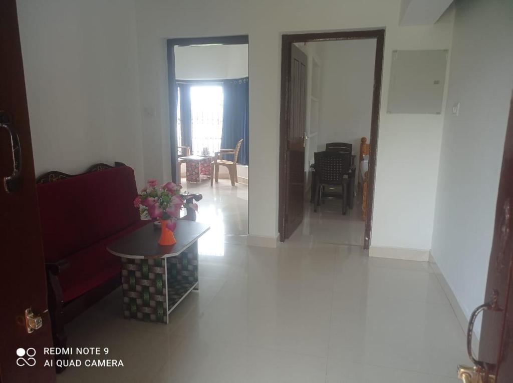 a living room with a red couch and a table at KODAIKANAL HOME STAY in Kodaikānāl