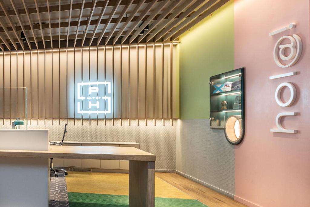 una habitación con una mesa y un reloj en la pared en Suites Plaza Hotel & Wellness, en Andorra la Vella