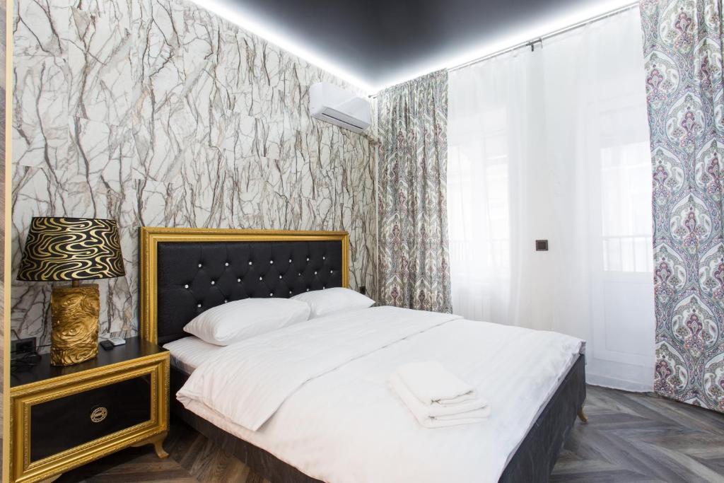 Sumskaya Apartment Lux في خاركوف: غرفة نوم بسرير وجدار مغطى بورق الجدران