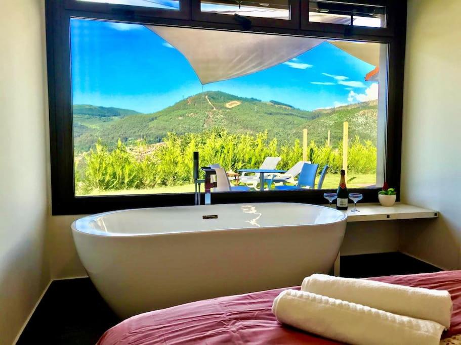 eine Badewanne in einem Zimmer mit einem großen Fenster in der Unterkunft Casa nueva en Vigo con Jacuzzi y chimenea in Pontevedra