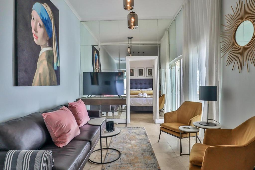 sala de estar con sofá y dormitorio en Beaumont Cottages 2 by CTHA, en Ciudad del Cabo