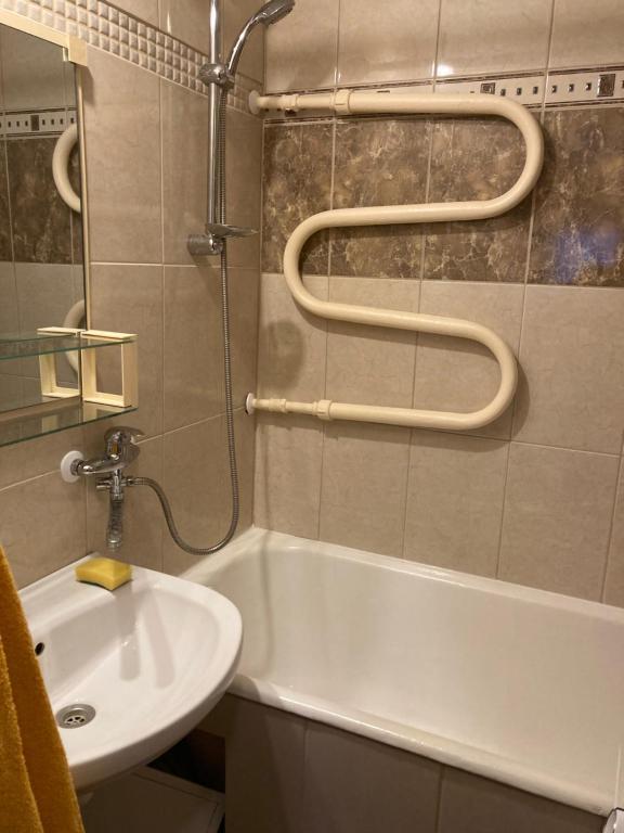 ein Badezimmer mit einem Waschbecken, einer Badewanne und einer Dusche in der Unterkunft Helge Guest Apartment in Valga