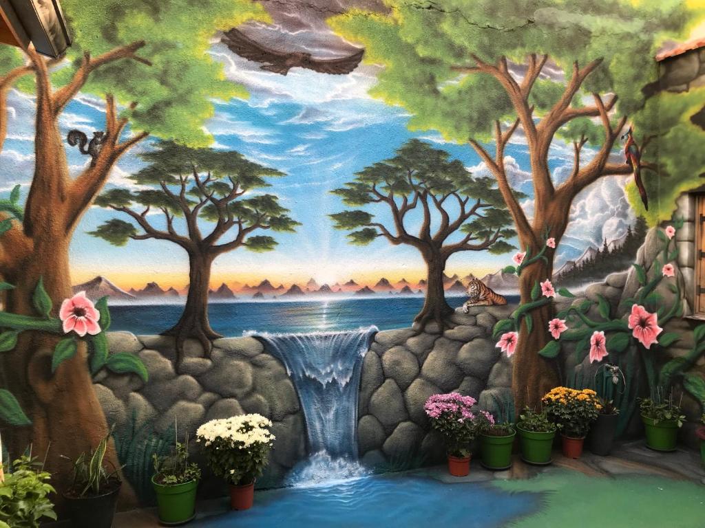 een muurschildering van een waterval en bomen en planten bij Zouglas App Guesthouse in Limassol