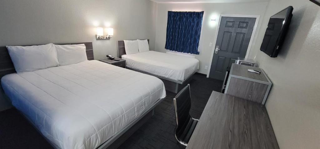 HenryettaにあるGreen Country Innのベッド2台とテレビが備わるホテルルームです。