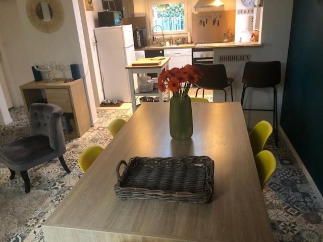 een tafel met een vaas met bloemen erop bij Dinard-jolie maison au calme proche plage in Dinard