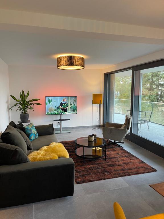 a living room with a couch and a table at Basalt Lodge am Lehnitzsee in Oranienburg