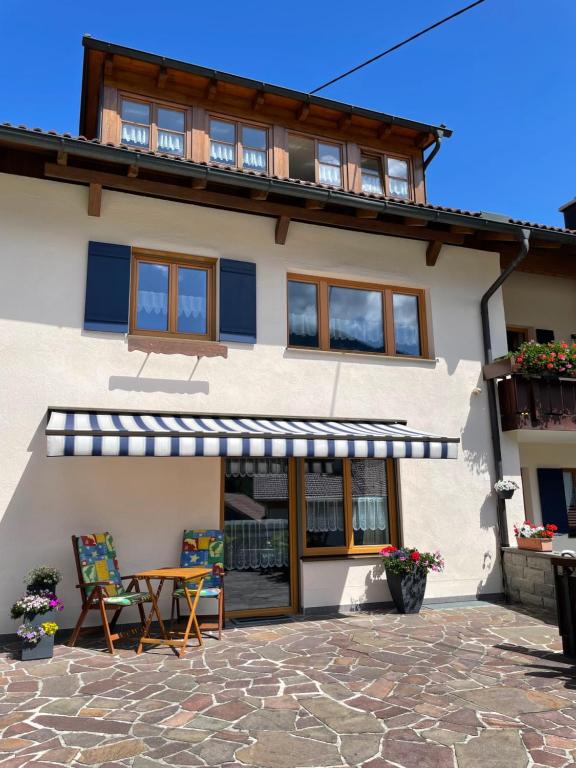 a house with a patio and a table and chairs at Ferienwohnung Falkenstein in Rettenberg