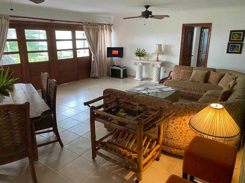 een woonkamer met een bank en een tafel bij Los Corozos Apartment G1 Guavaberry Golf & Country Club in Juan Dolio
