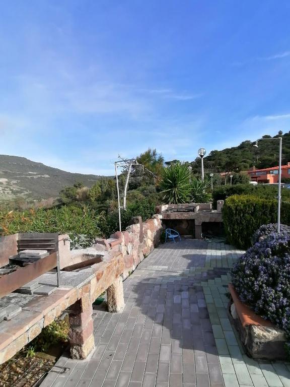 park z ławkami i kwiatami na wzgórzu w obiekcie Appartamento vista mare con terrazza Bosa Turas w mieście Magomadas