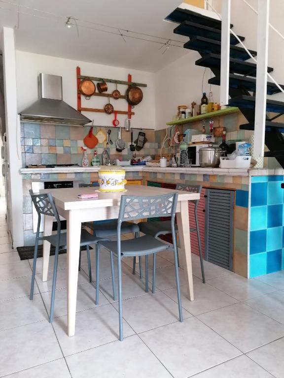 kuchnia ze stołem i krzesłami w kuchni w obiekcie Appartamento vista mare con terrazza Bosa Turas w mieście Magomadas