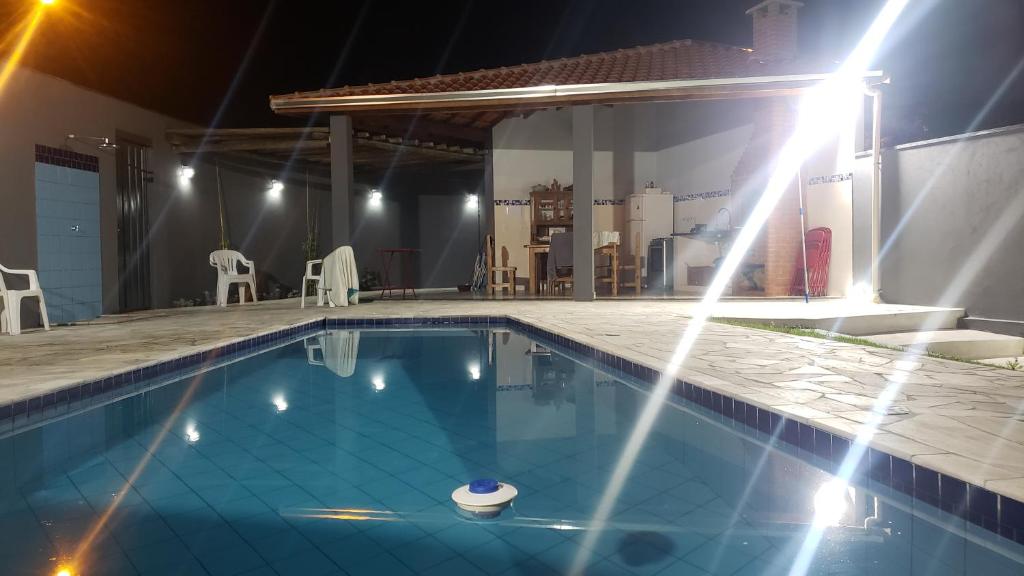 una piscina por la noche con luces en Chácara Águas São Pedro en Águas de São Pedro