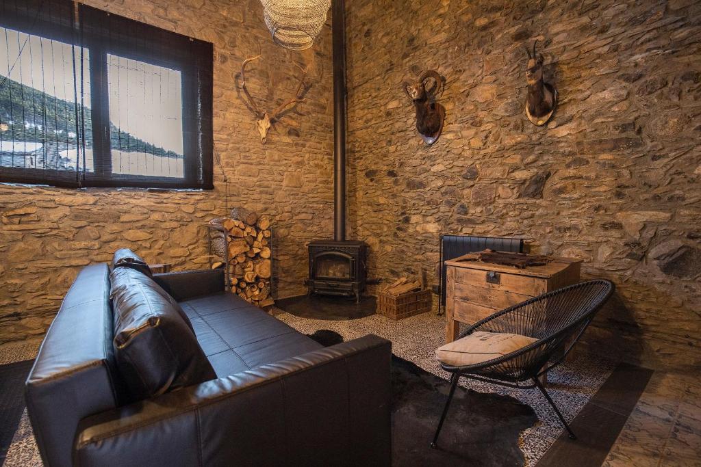 a living room with a leather couch and a chair at JAT MOUNTAIN HOUSES - Casa Pairal Jarca - dúplex - a 1 km de Canillo in Canillo