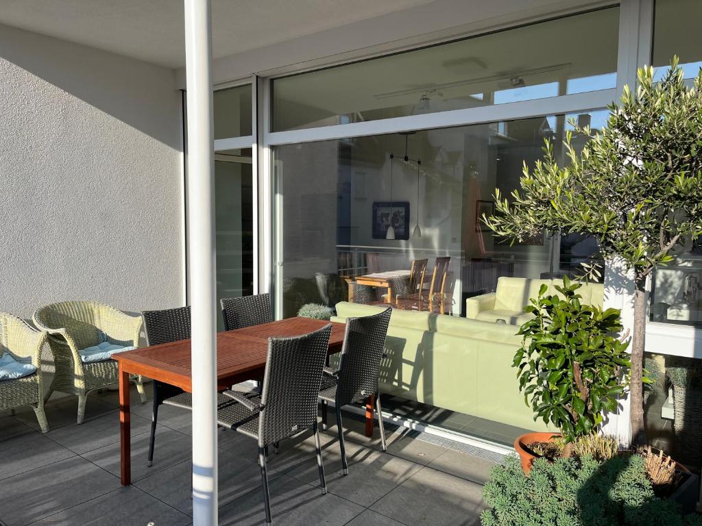 a patio with a wooden table and chairs at Sonnige Wohnung im Herzen von Bühl in Bühl