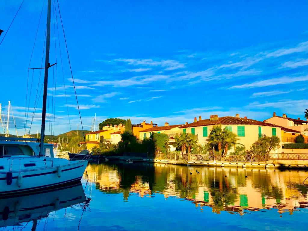 un bateau est amarré dans un port avec des bâtiments dans l'établissement Cap Sud, sea & sun, à Grimaud
