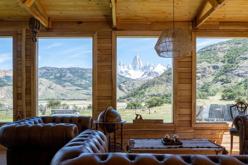 uma sala de estar com sofás e vista para as montanhas em Estancia Bonanza em El Chaltén