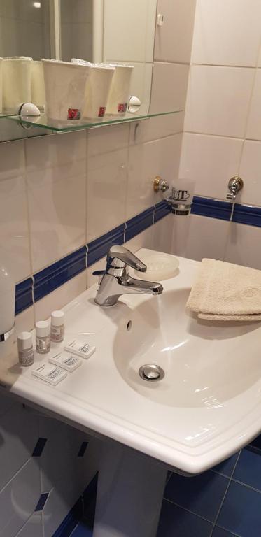 y baño con lavabo blanco y espejo. en hebergement-luxeuil-les-bains, en Luxeuil-les-Bains