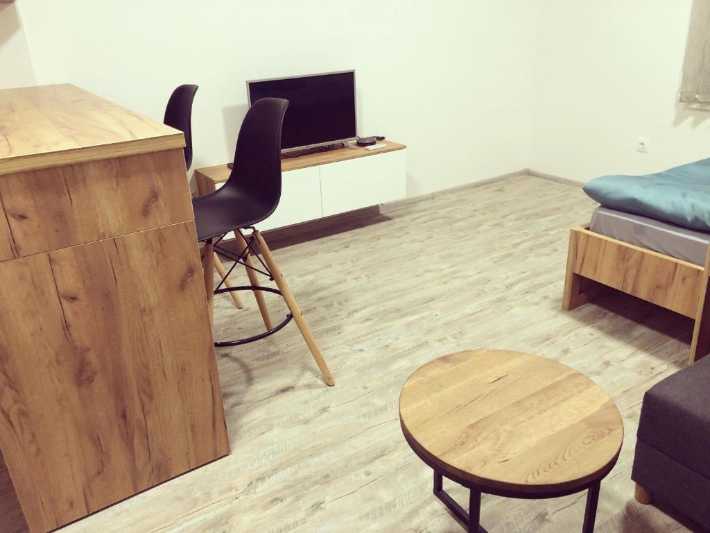 - un salon avec un bureau, une chaise et une table dans l'établissement Apartman Lena, à Prijedor