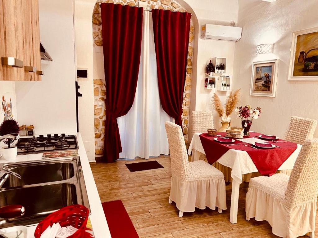 a kitchen with a table with red curtains and a stove at Le Chalet Palermo Centro in Palermo