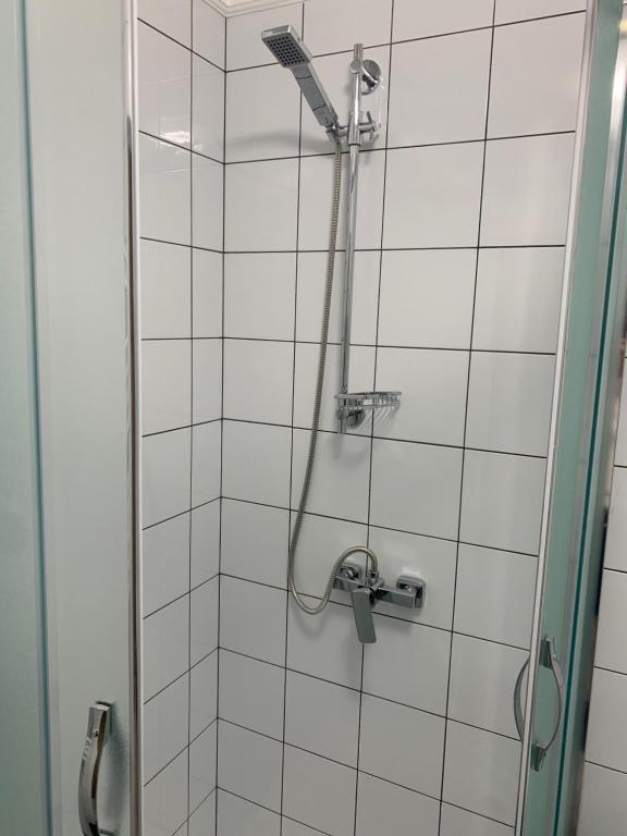 a shower in a bathroom with white tiles at Зручні апартаменти подобово! Центр. Руська. 3 кімн. in Ternopilʼ