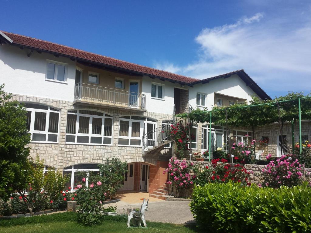 a house with a dog in front of it at Pansion Pero Elez Medjugorje in Međugorje