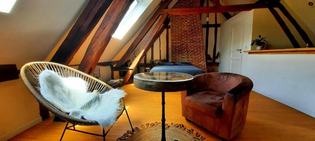 een woonkamer met twee stoelen en een tafel bij Loft de charme á 150m de la cathédrale in Beauvais