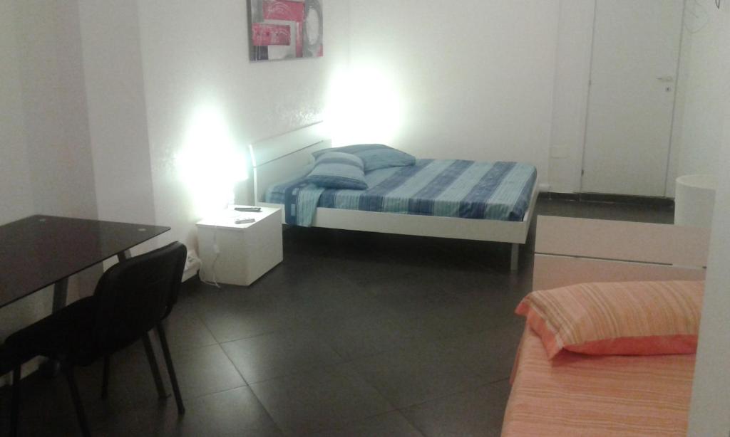 - une petite chambre avec un lit, une table et des chaises dans l'établissement Ipanema Suite, à Margherita di Savoia