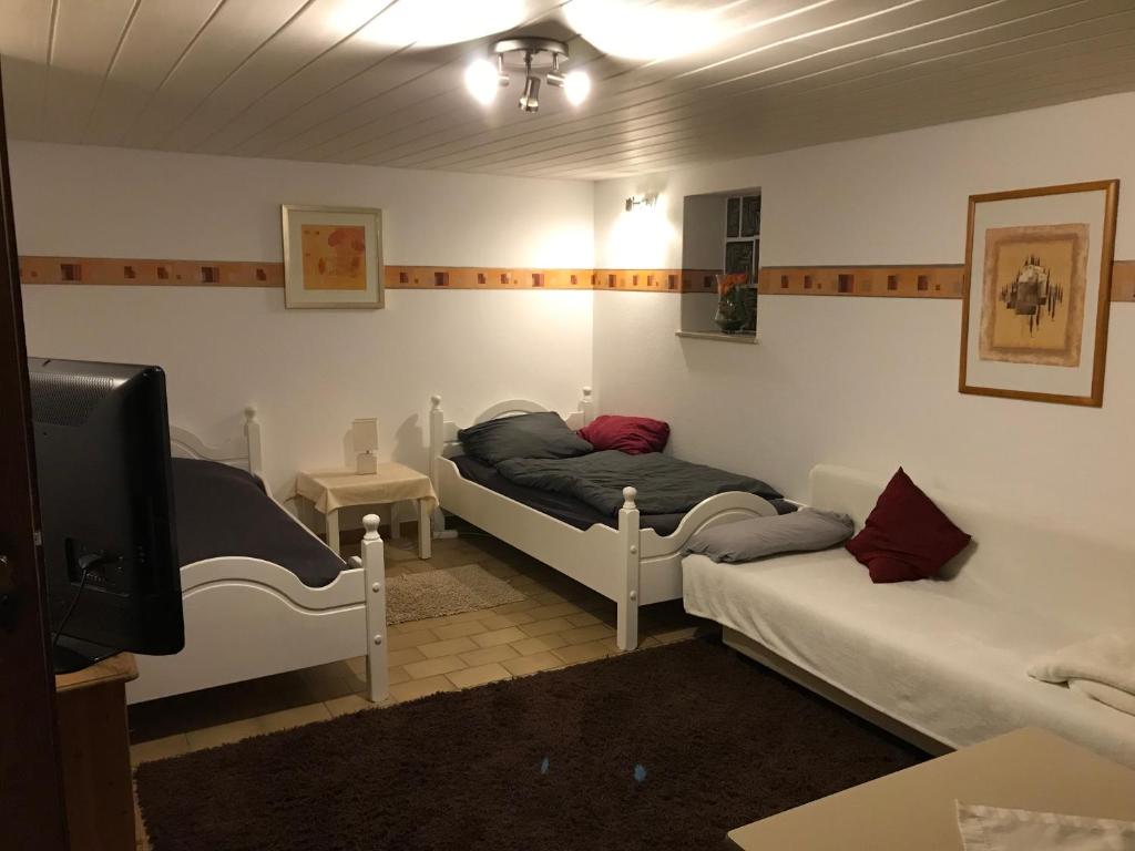 a room with two beds and a flat screen tv at Ferienwohnung Sandner in Porta Westfalica