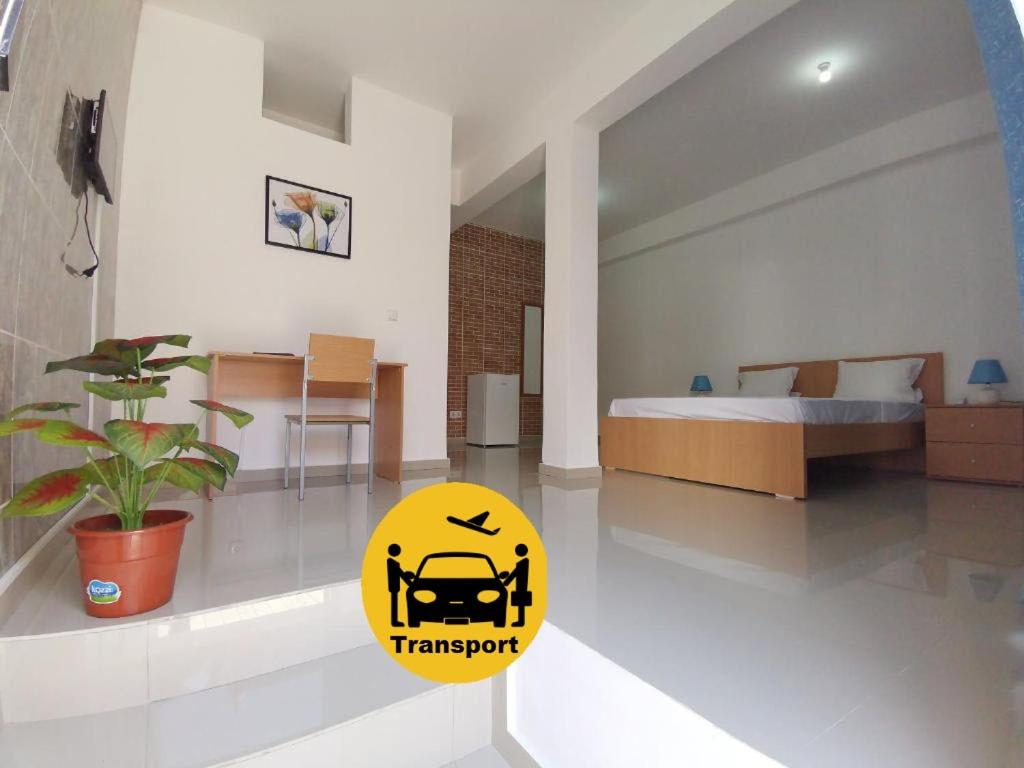 a bedroom with a bed and a yellow sign on the floor at Plateau Bedroom & Chambre - Praia Center 1 in Praia