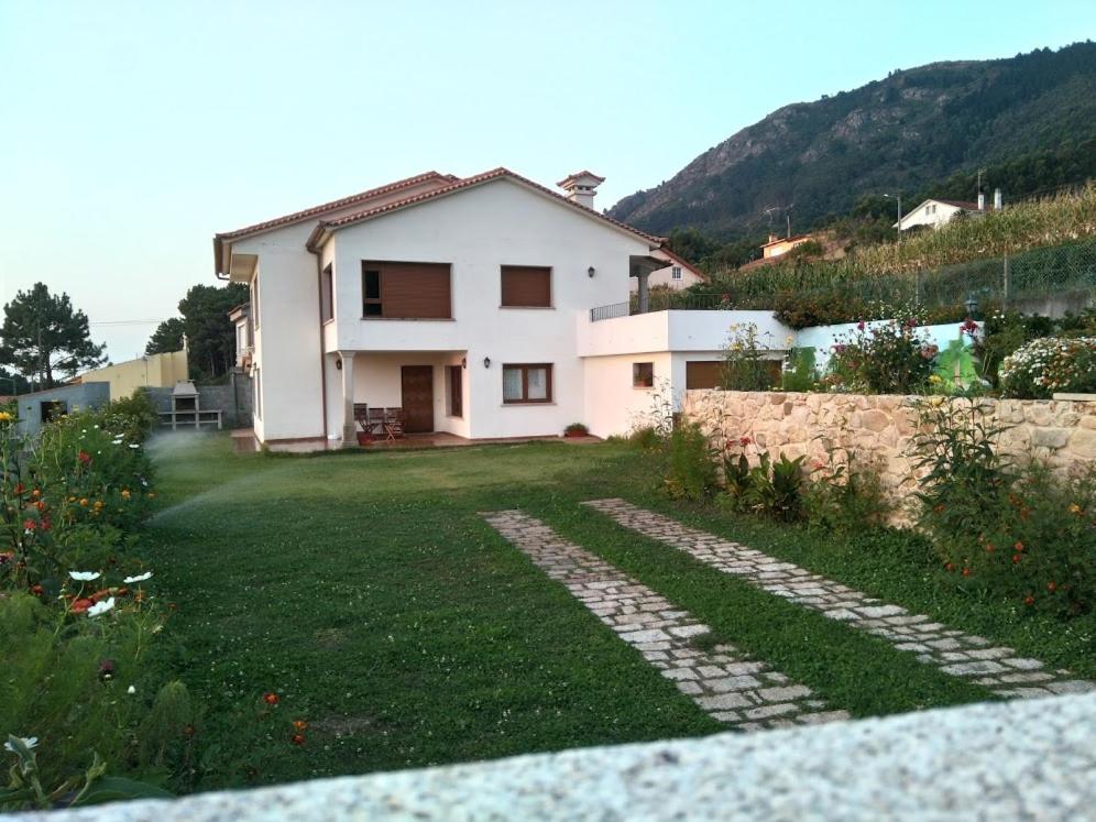 a house on a hill with a green yard at CASA ALICIA VIVIENDA USO TURISTICO Peregrinos in A Guarda