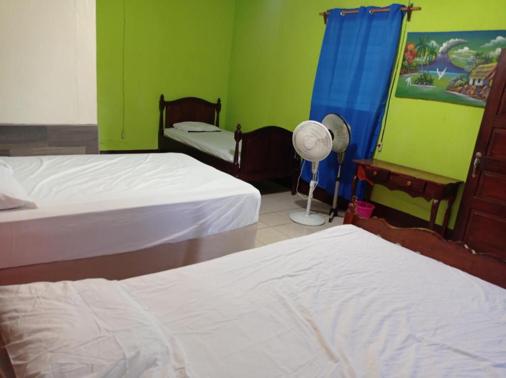 a hotel room with two beds and a fan at Loren's house in Moyogalpa