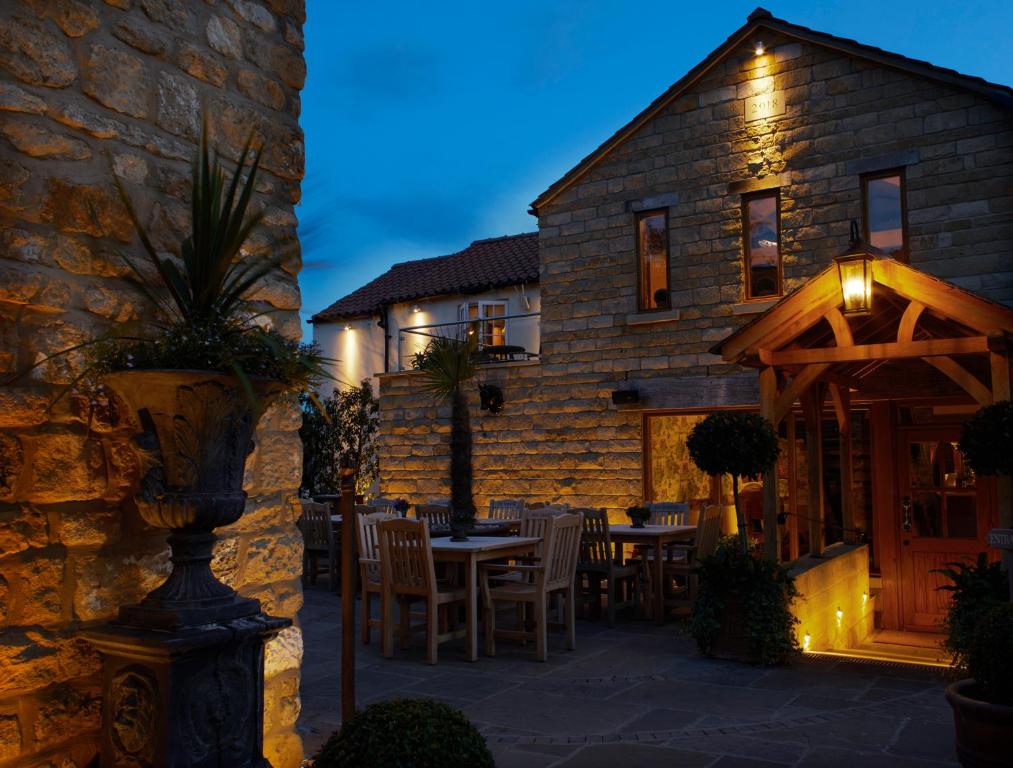 una casa de piedra con una mesa y sillas delante de ella en The Farrier en Scarborough