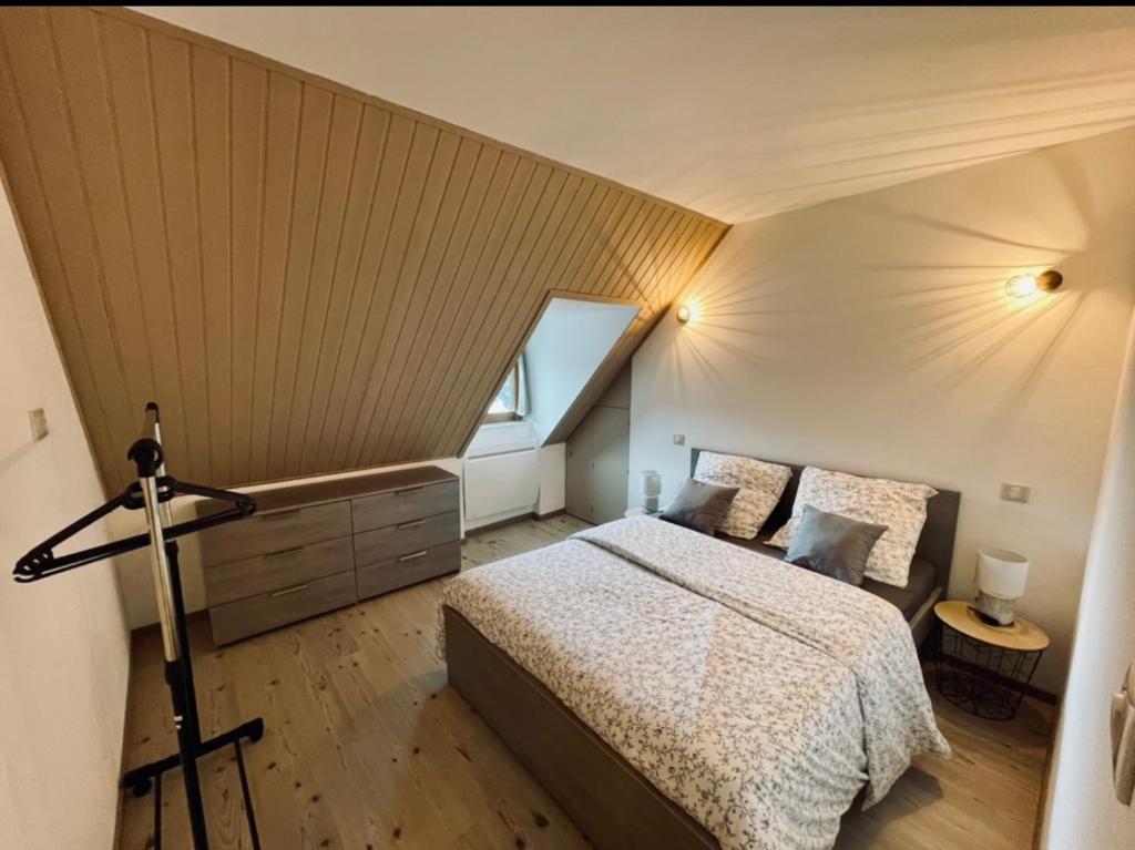 sypialnia z dużym łóżkiem na poddaszu w obiekcie Gîte de Mende w mieście Mende